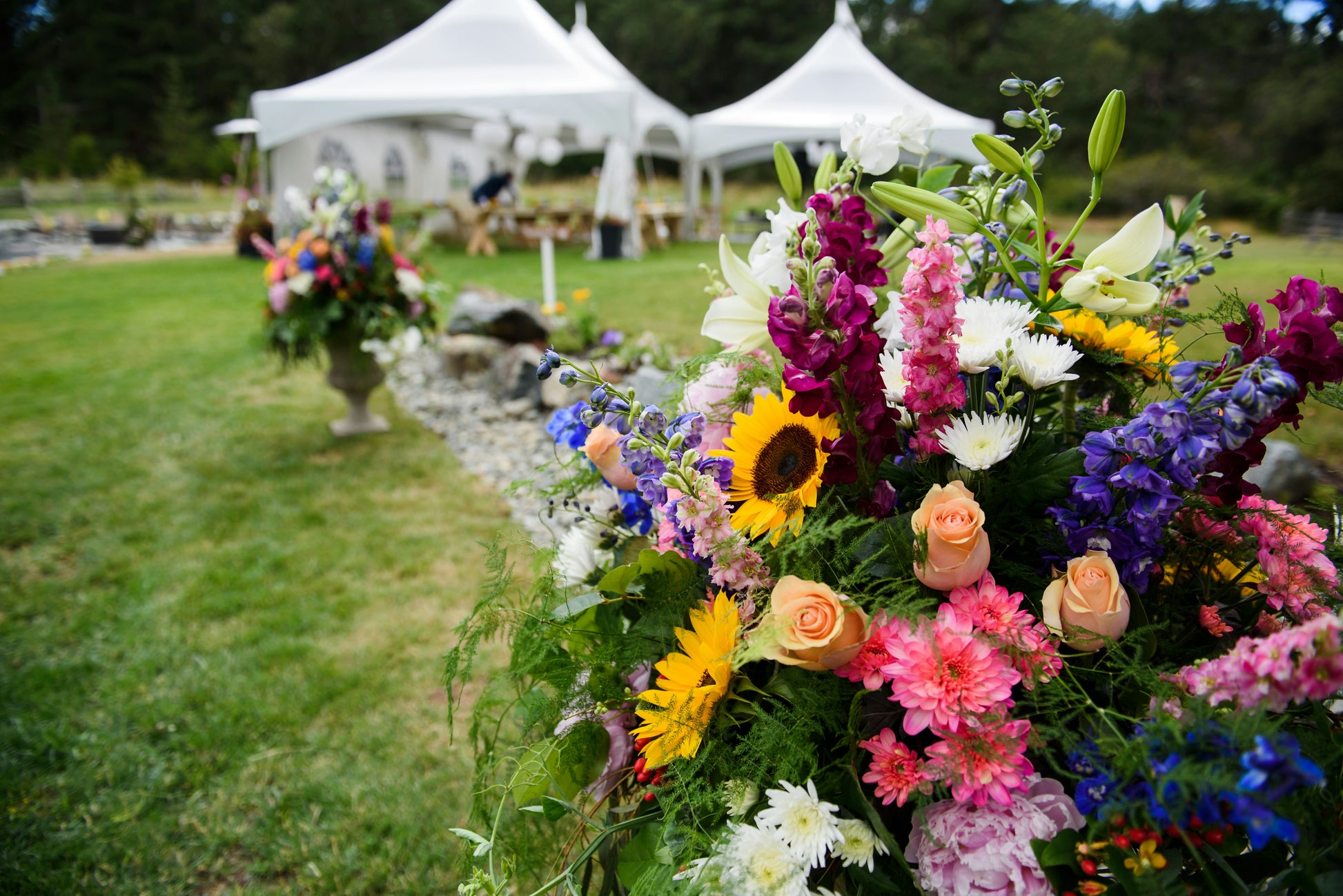 Backyard wedding with flowers and high peak tents